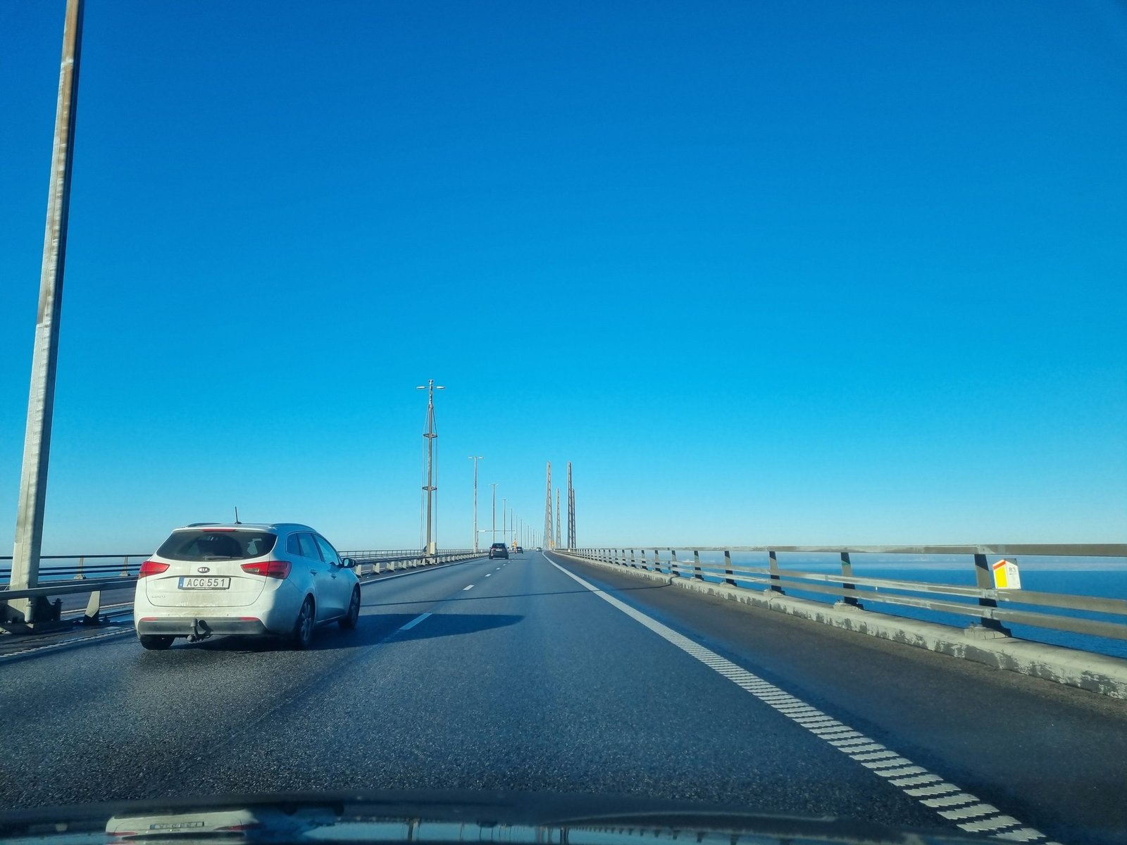 Autolla Juutinrauman sillan yli ruotsalaisen henkilöauton perässä, pylonit näkyvät kaukana